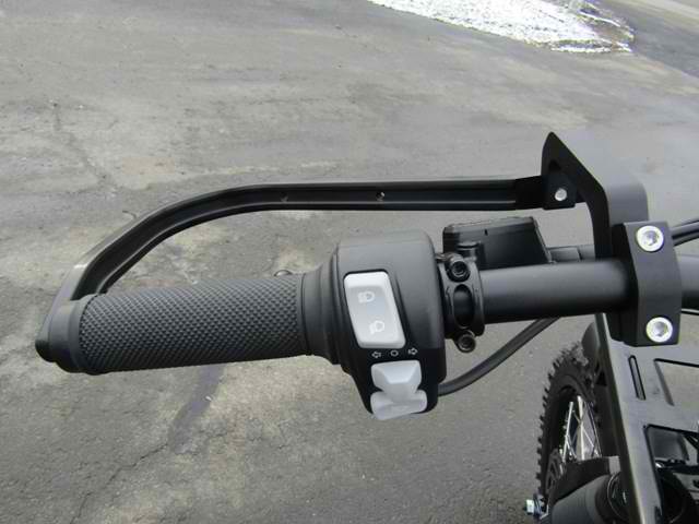 A close up of a motorcycle handlebar with a switch on it