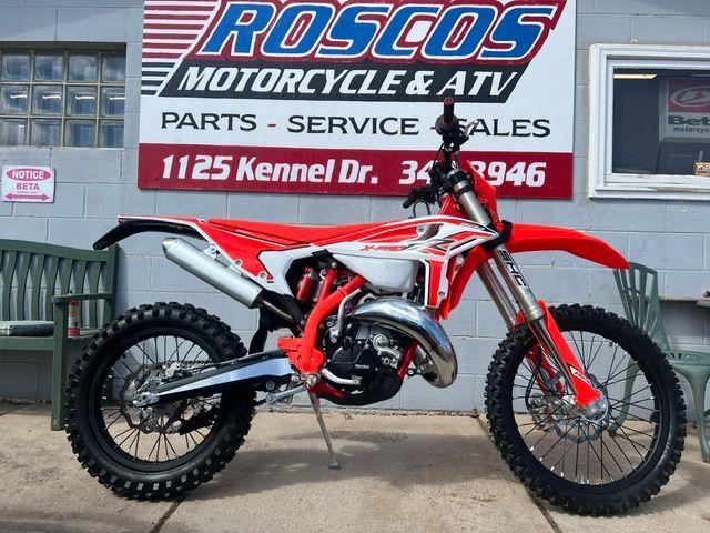 Red and white dirt bike parked outside Rosco’s Motorcycle service shop