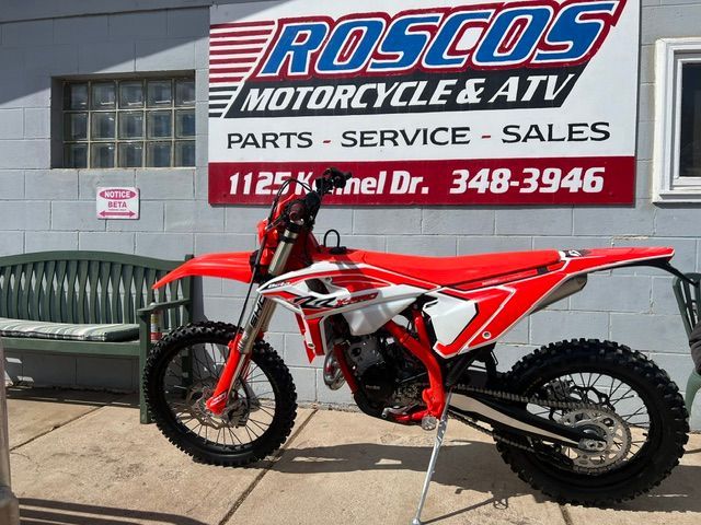 Red dirt bike parked outside Rosco’s Motorcycle & ATV parts and service shop