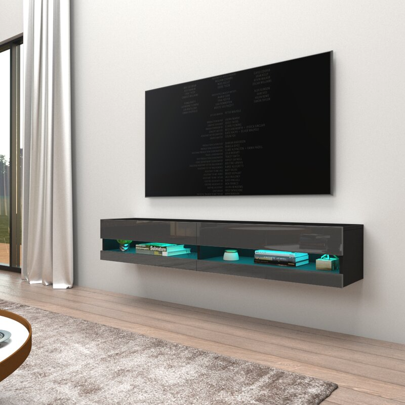 A modern living room with a wall-mounted TV above a floating entertainment unit with blue LED lighting.