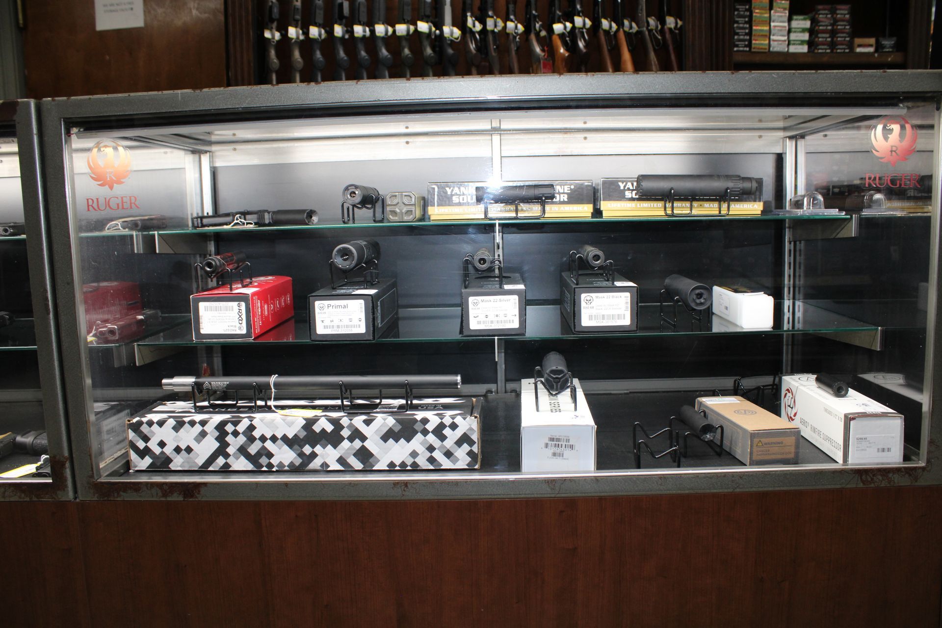 Display case with several boxed watch or jewelry items arranged on shelves inside a store.