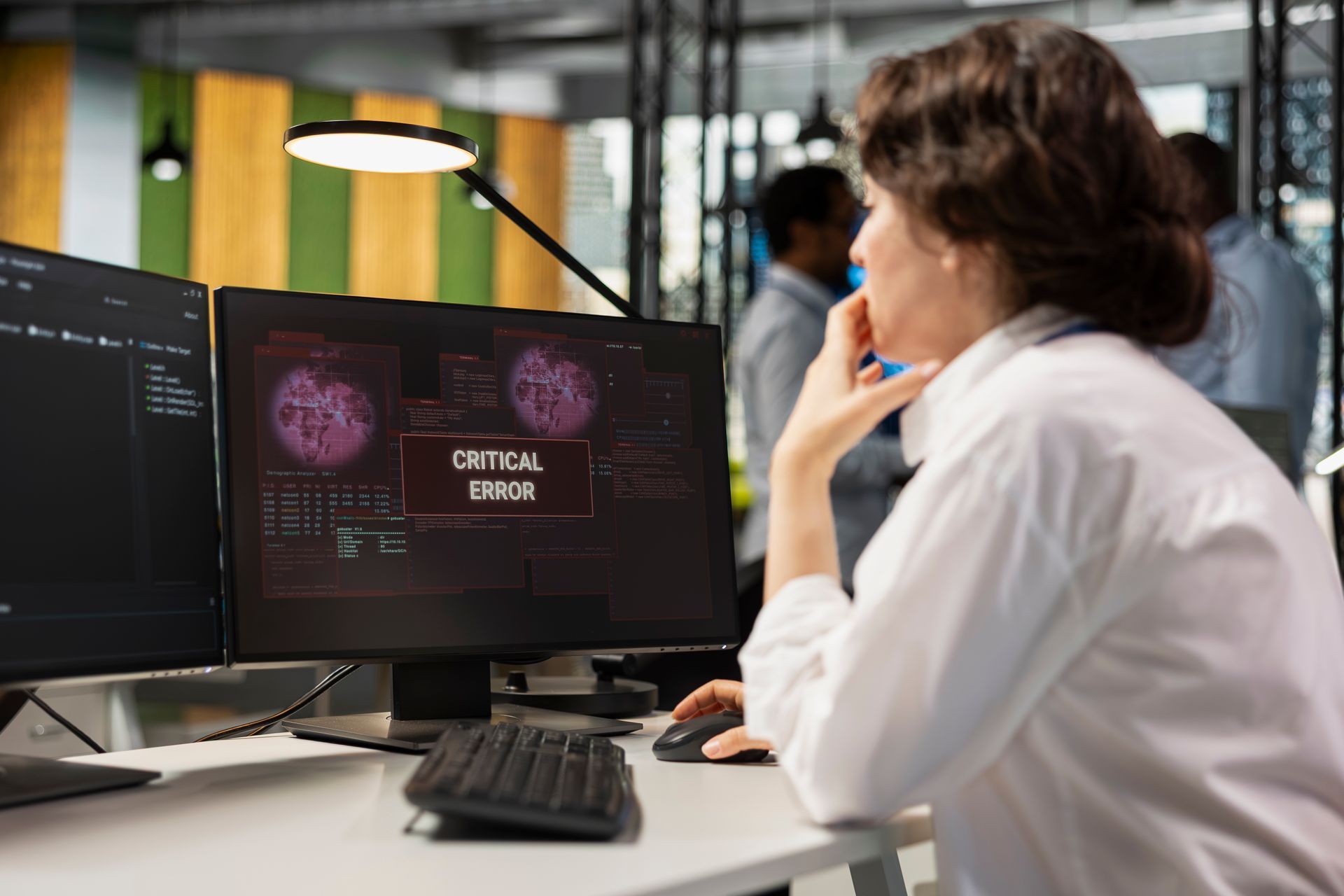 Profissional de TI em escritório diante de monitor exibindo a mensagem 