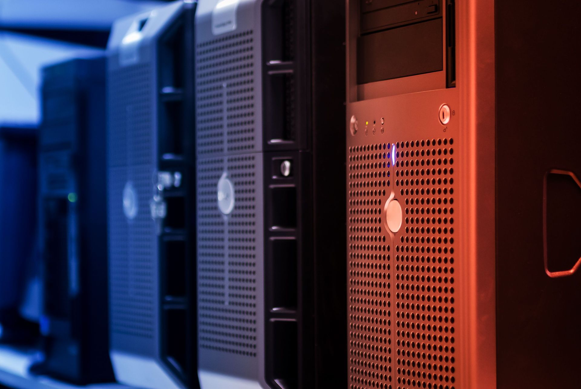 Fileira de torres de servidor pretas e vermelhas em um data center, iluminadas por luzes azuis