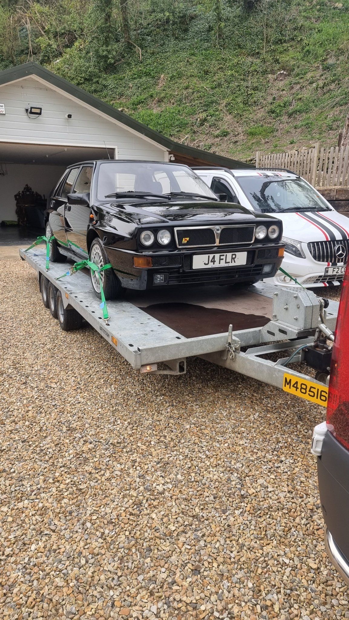 A Lancia HF on a trailer towed by a Mercedes Sprinter, ready for transport by MTC Transport