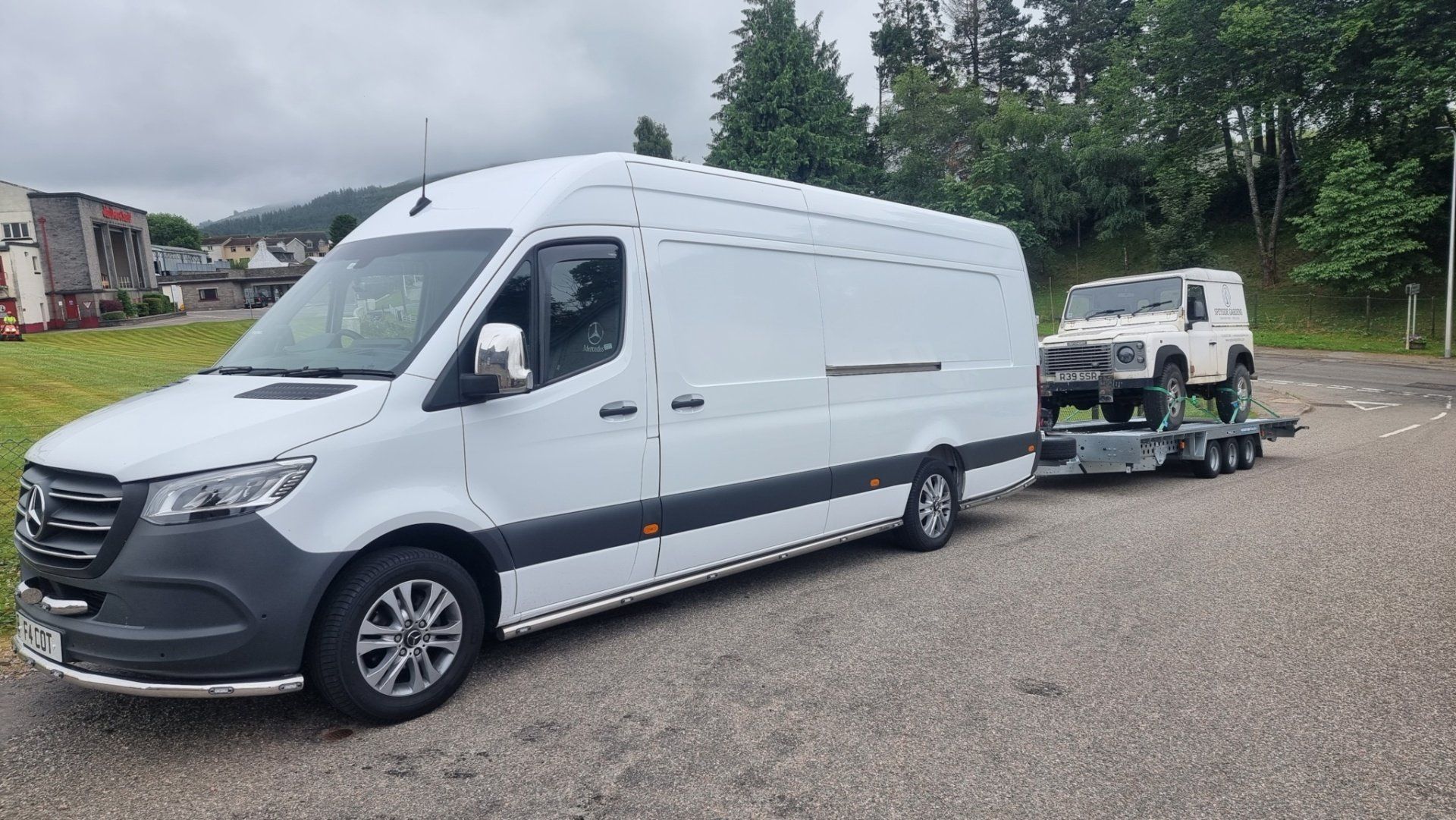 A classic Landrover on a trailer towed by a Mercedes Sprinter, ready for transport by MTC Transport