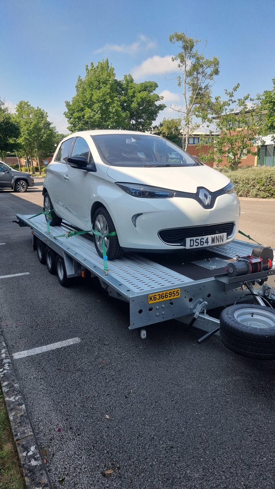 A white Renault on a trailer towed by a Mercedes Sprinter, ready for transport by MTC Transport