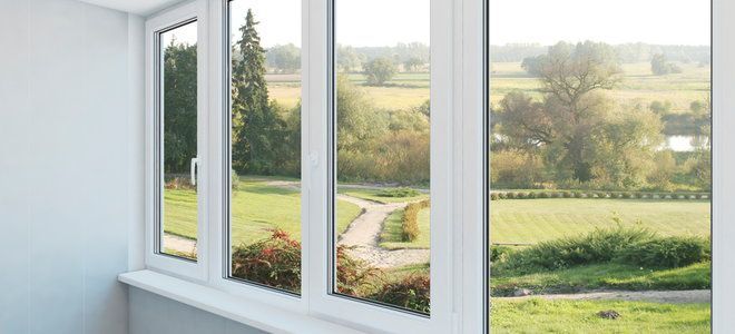A room with a lot of windows and a view of a field.