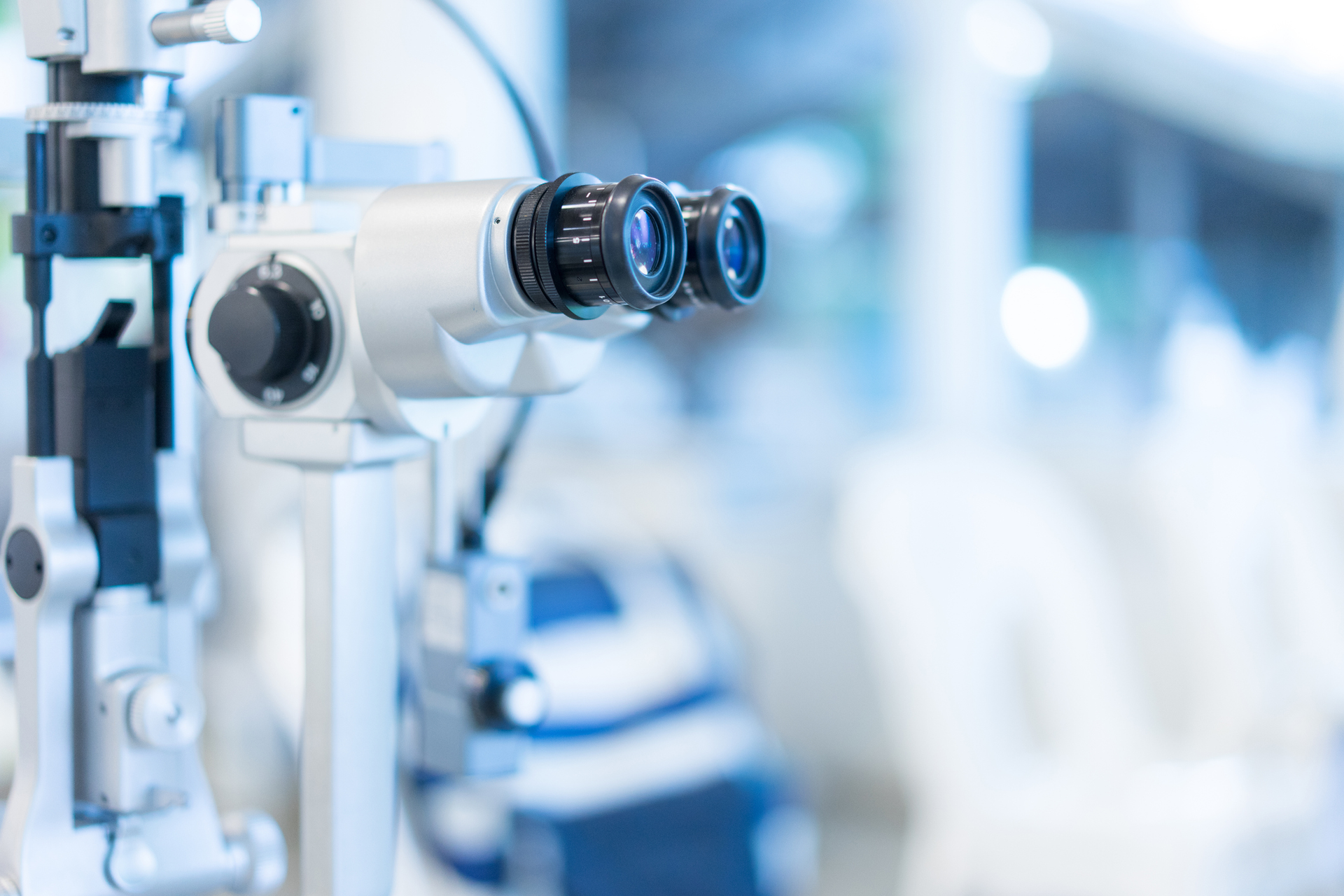 Slit lamp eye examination device, close-up, focusing on dual eyepieces in a medical setting.