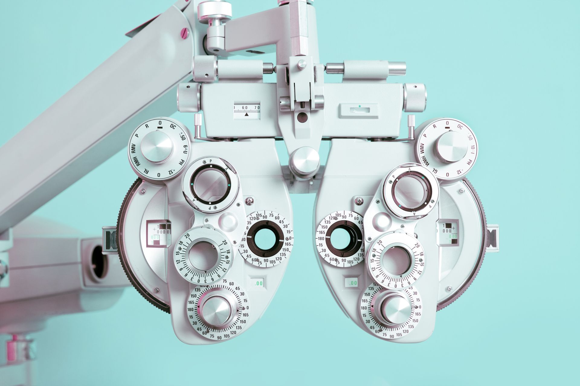 Phoropter used for vision testing, white instrument on a blue background.