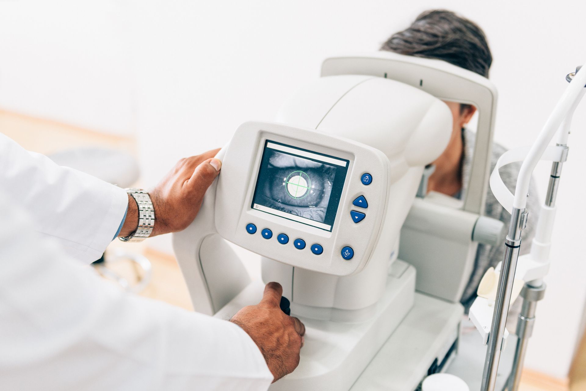 Doctor using eye exam machine on a patient. Machine displays eye scan.