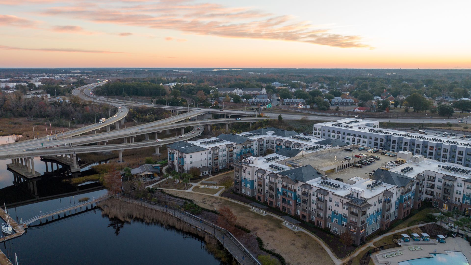 Aerial view of a river, bridge, and modern apartment buildings at sunset. Aerial view of a river, bridge, and modern apartment buildings at sunset.