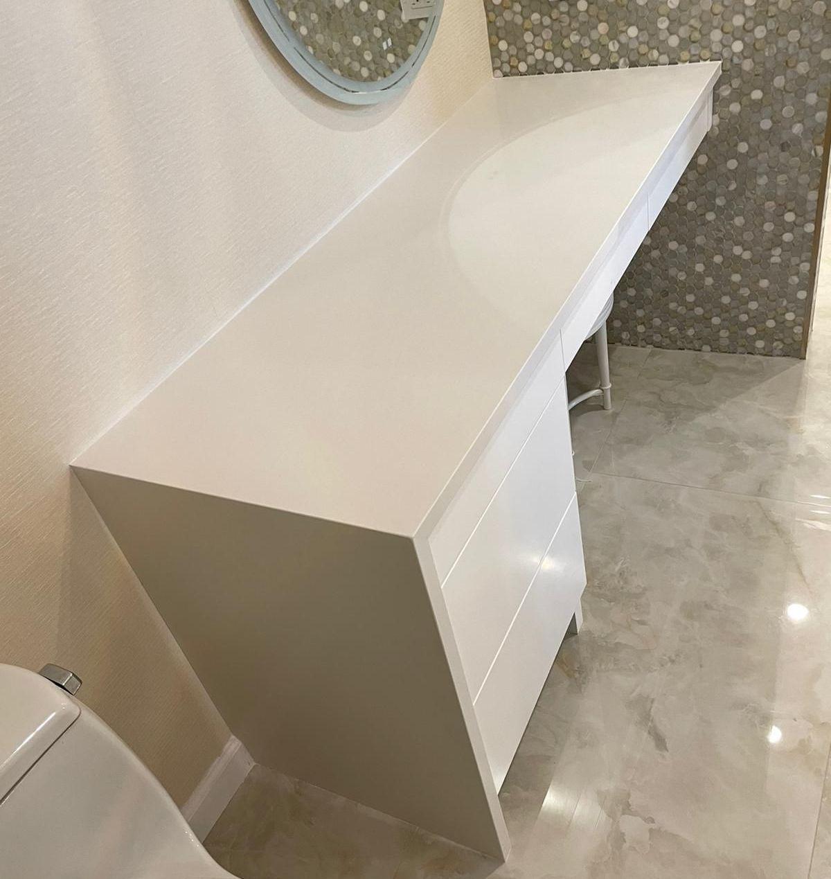 A bathroom with a white vanity and a toilet.