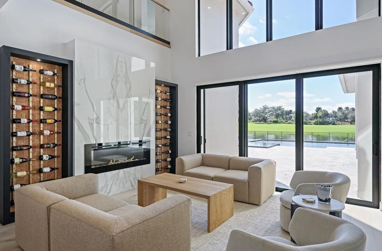 A living room with a couch, chairs, coffee table and fireplace.
