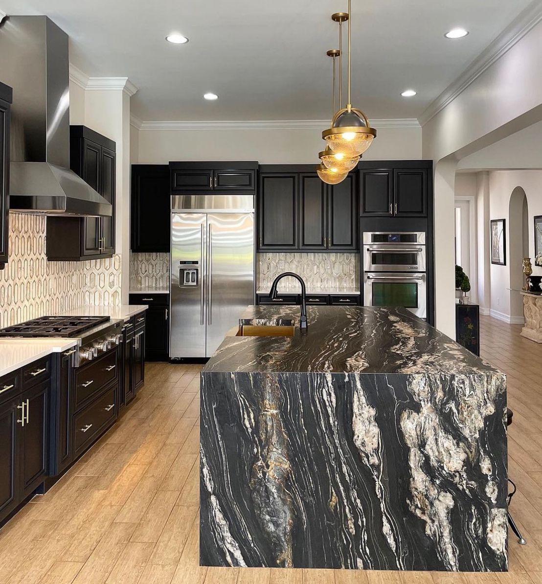 A kitchen with black cabinets and stainless steel appliances.
