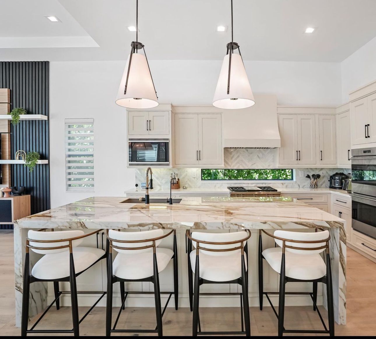 A kitchen with white cabinets and a marble counter top.