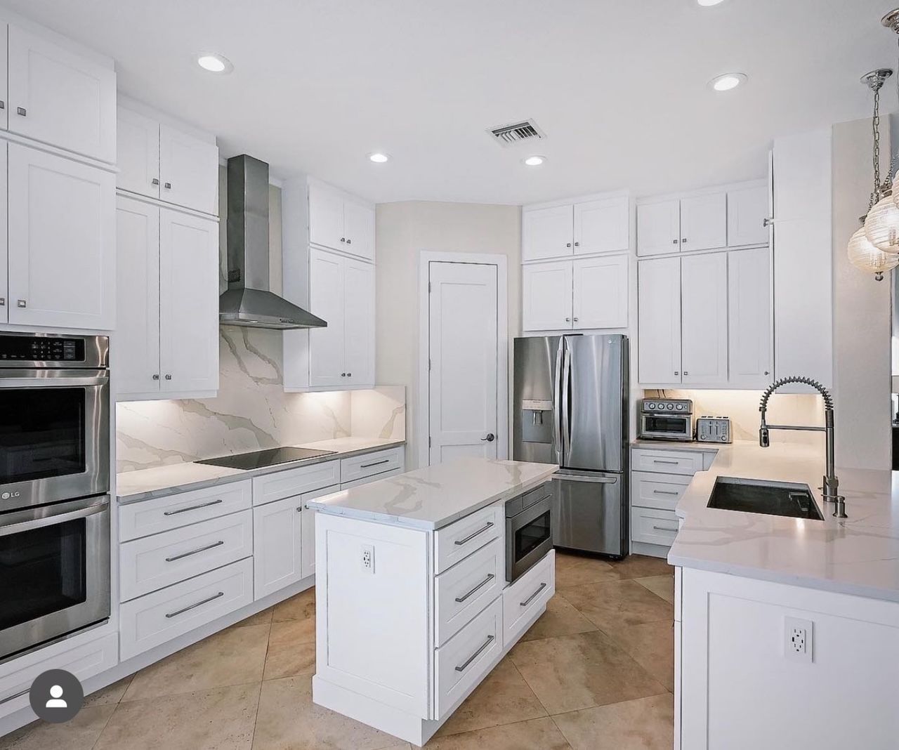 A kitchen with white cabinets and stainless steel appliances.