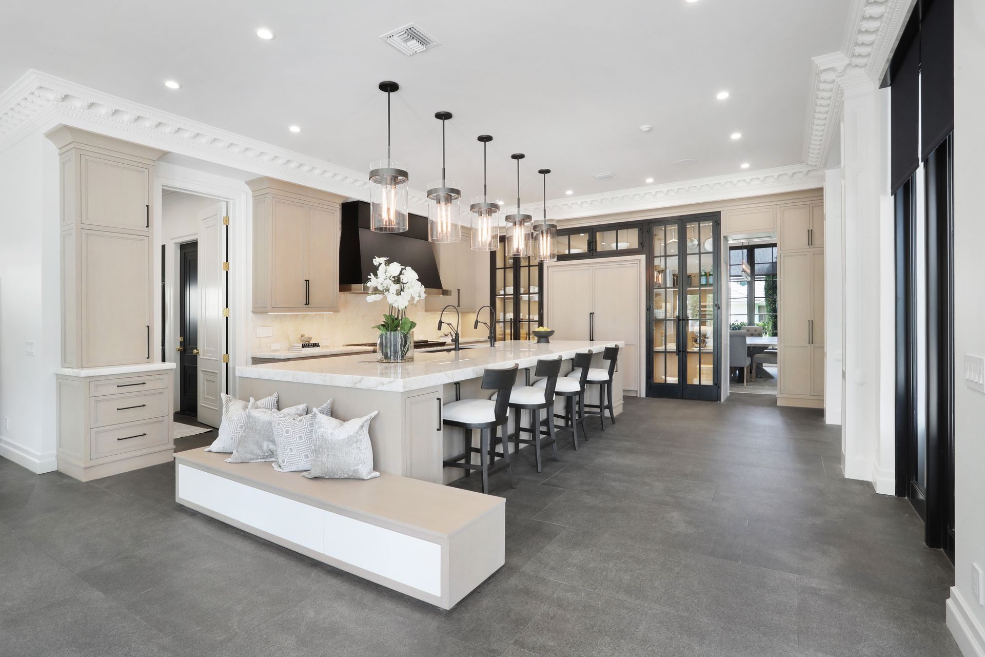 A large kitchen with a long island and stools.