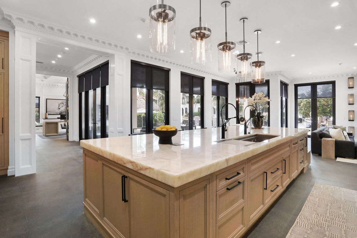 A modern kitchen with a marble counter top and stainless steel appliances.