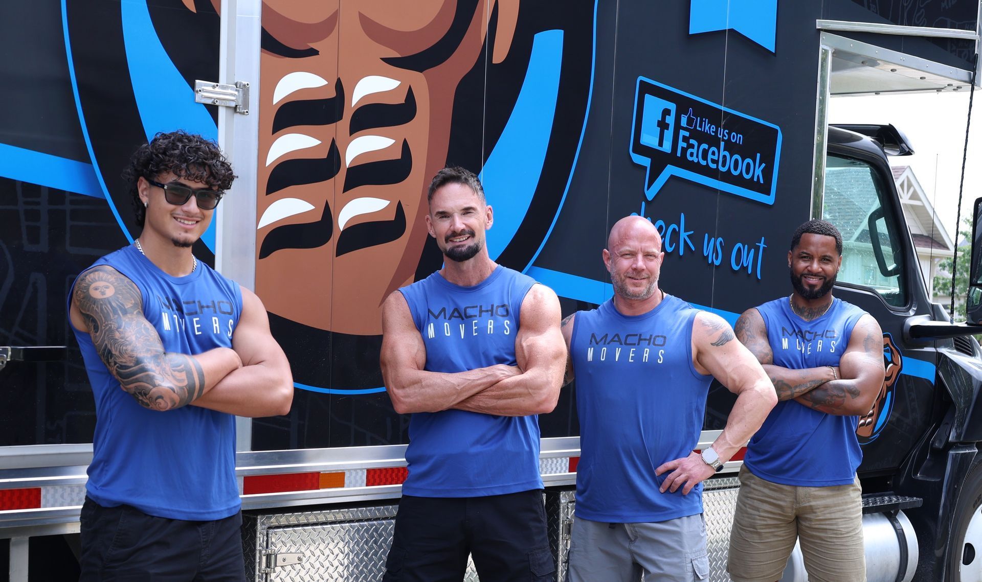 Four men in blue athletic tank tops standing with arms crossed in front of a fitness truck with a graphic of muscles.