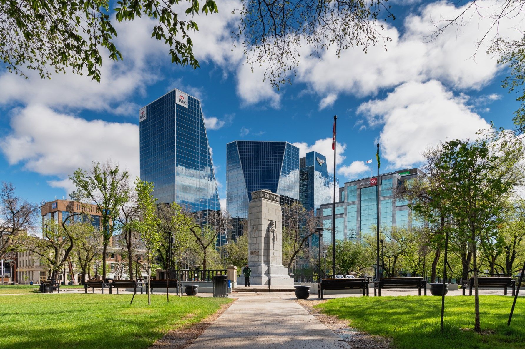 A park with tall buildings in the background on a sunny day.