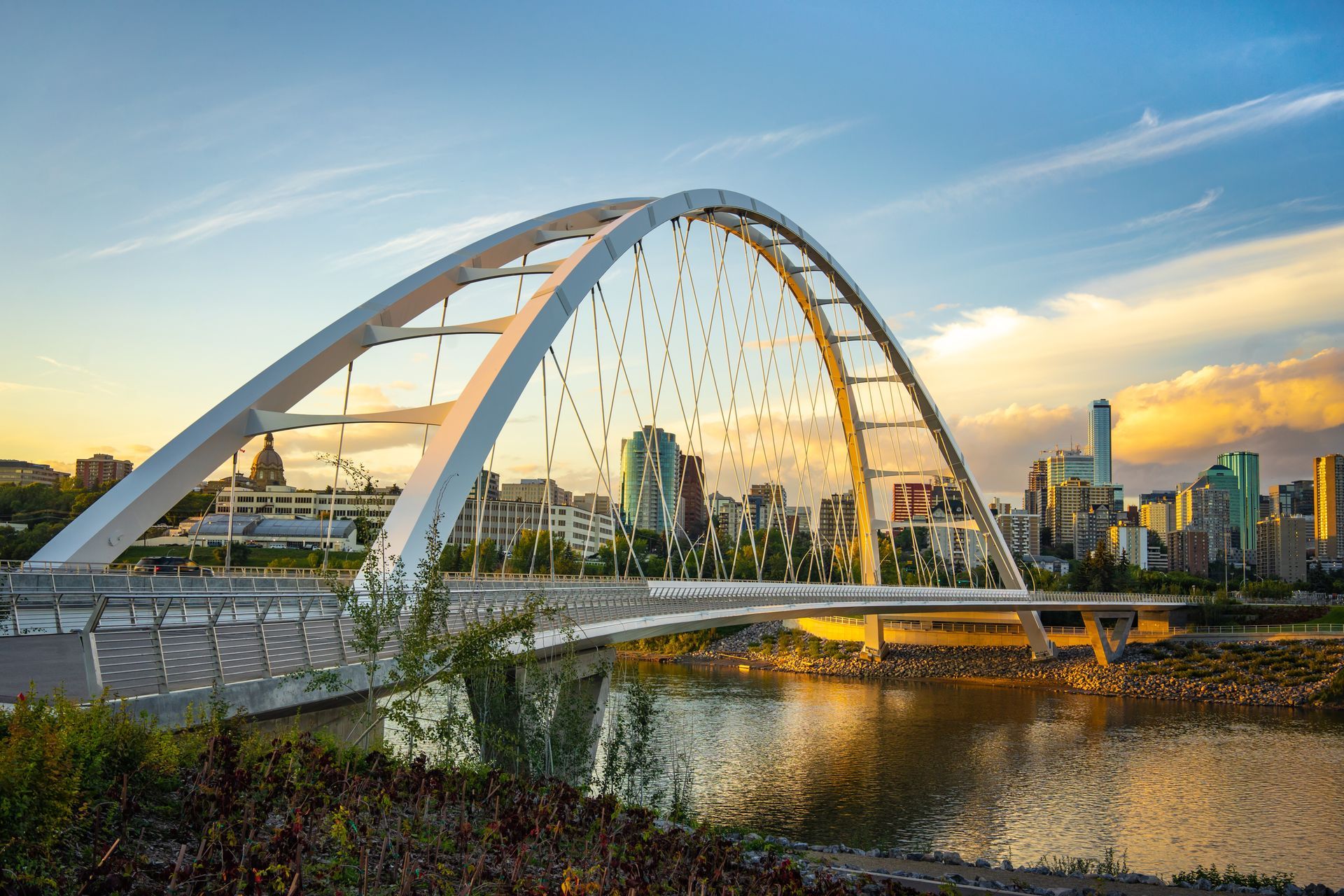 A bridge over a body of water with a city in the background.