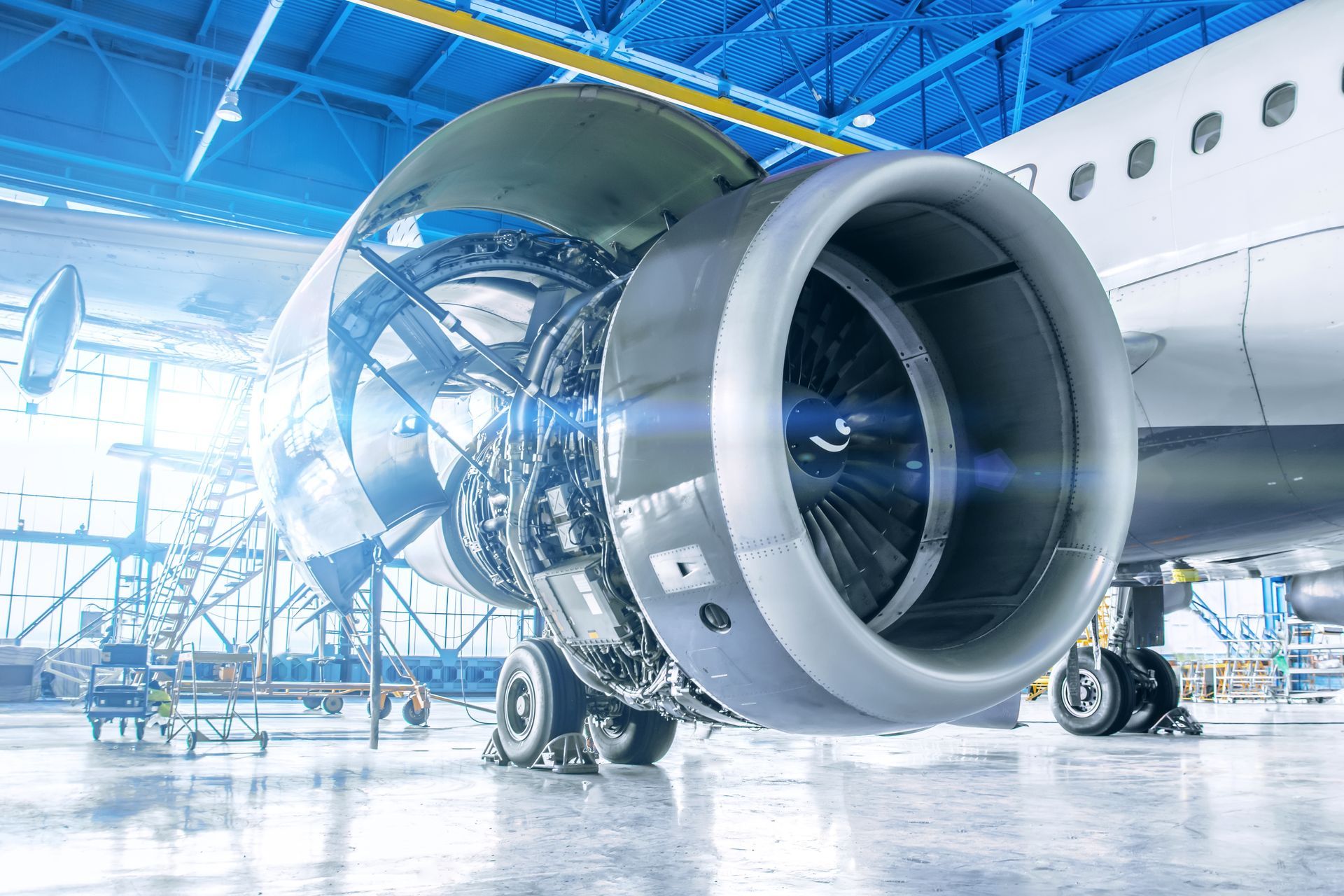 Aircraft engine, open in a maintenance bay, blue and silver, detailed.