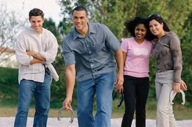 A group of people are standing next to each other holding horseshoes.