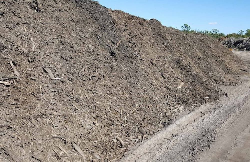 Large Pile of Dark Brown Mulch — Coastal Sand Soil & Mulch in Burrum heads, QLD