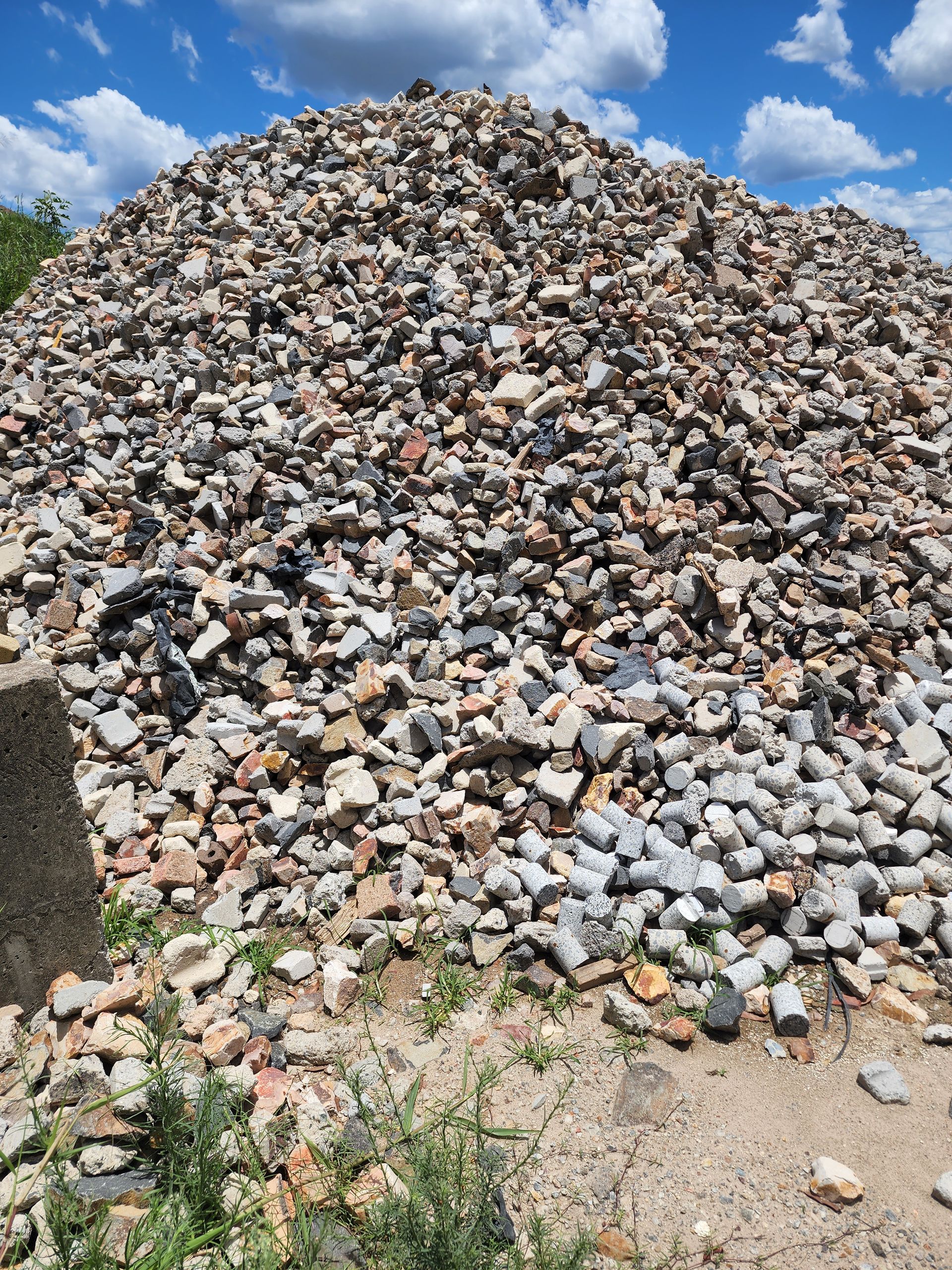 Large Pile of Mixed Rubble and Stones Outdoors Under a Blue Sky With Clouds — Coastal Sand Soil & Mulch in Maryborough, QLD