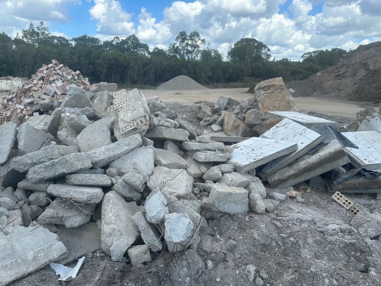 Pile Of Broken Concrete Rubble at a Construction Site Under a Cloudy Sky — Coastal Sand Soil & Mulch Craignish, QLD