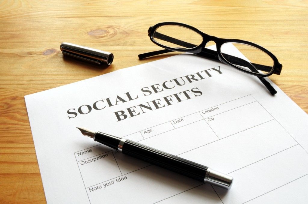 Social Security benefits form with pen and glasses on a wooden desk