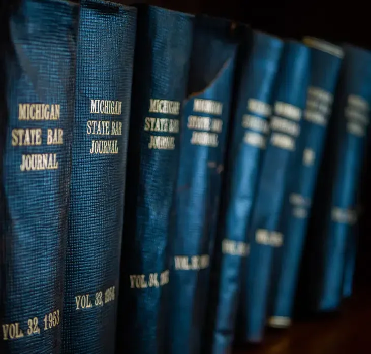 Row of blue Michigan State Bar Journal volumes on a shelf