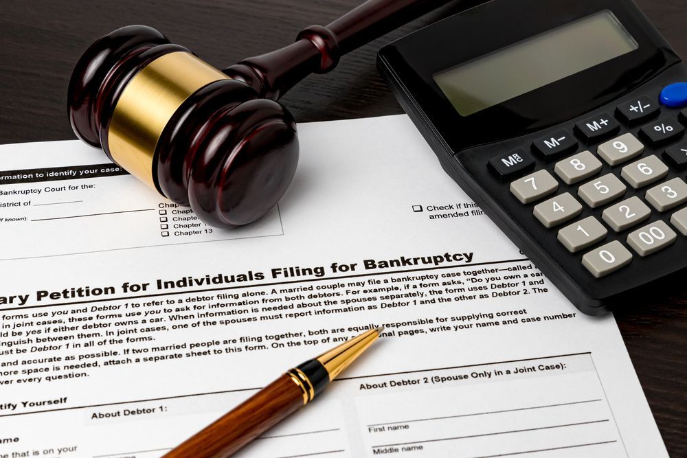 Gavel, calculator, pen, and legal form on a desk, suggesting court or tax paperwork