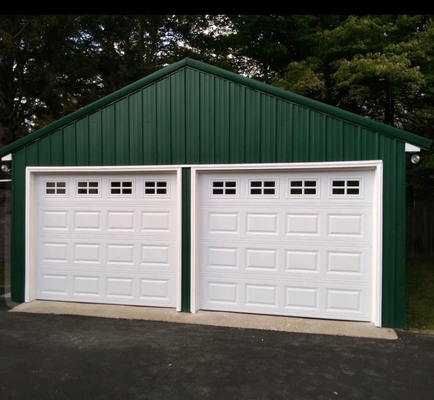 Green metal garage with white garage doors.
