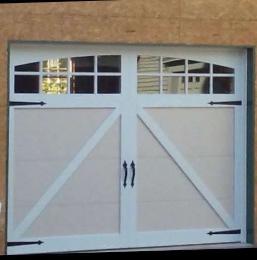 White garage door with windows, decorative black hinges and handles.