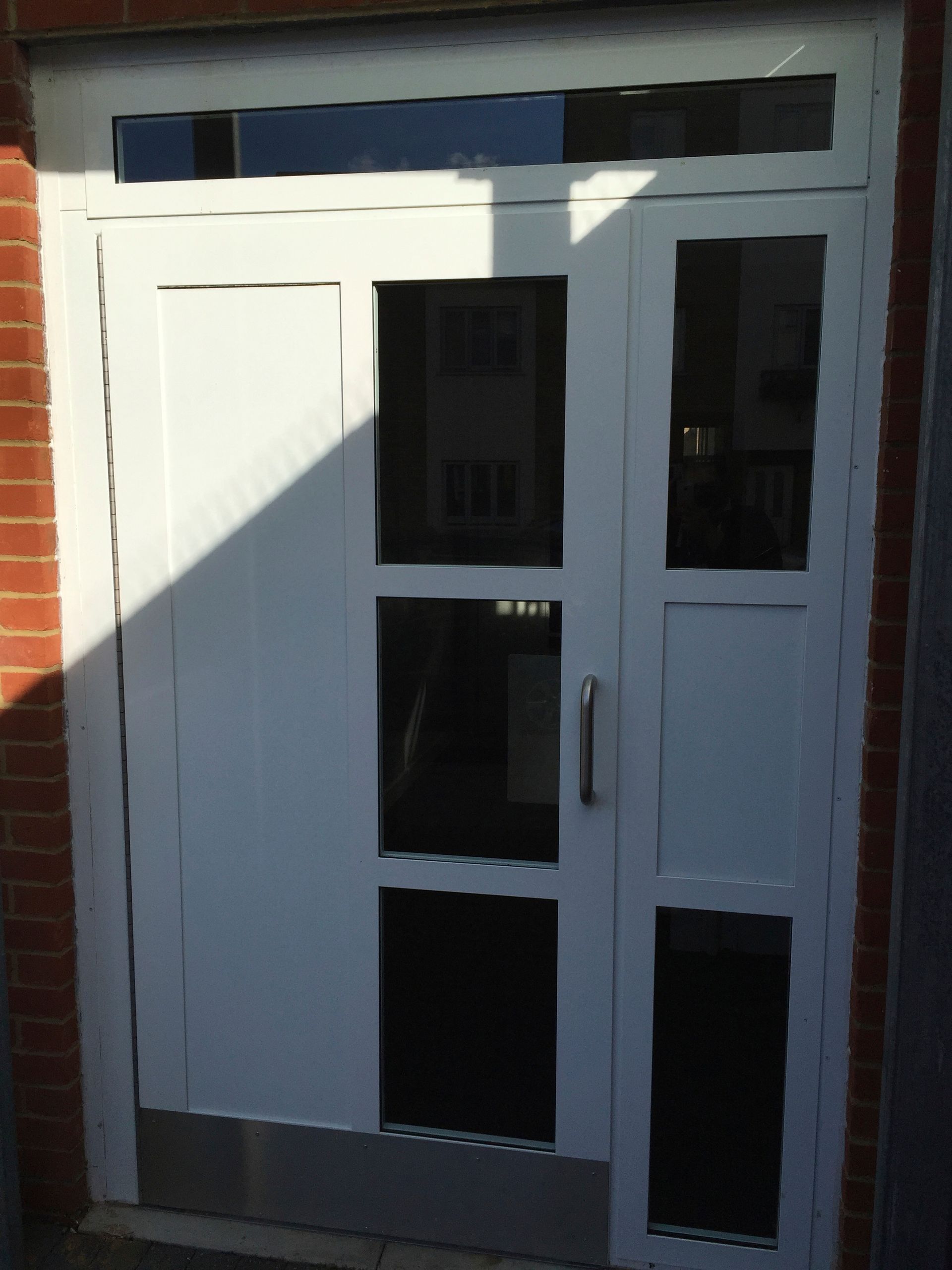 a white door with a brick wall behind it