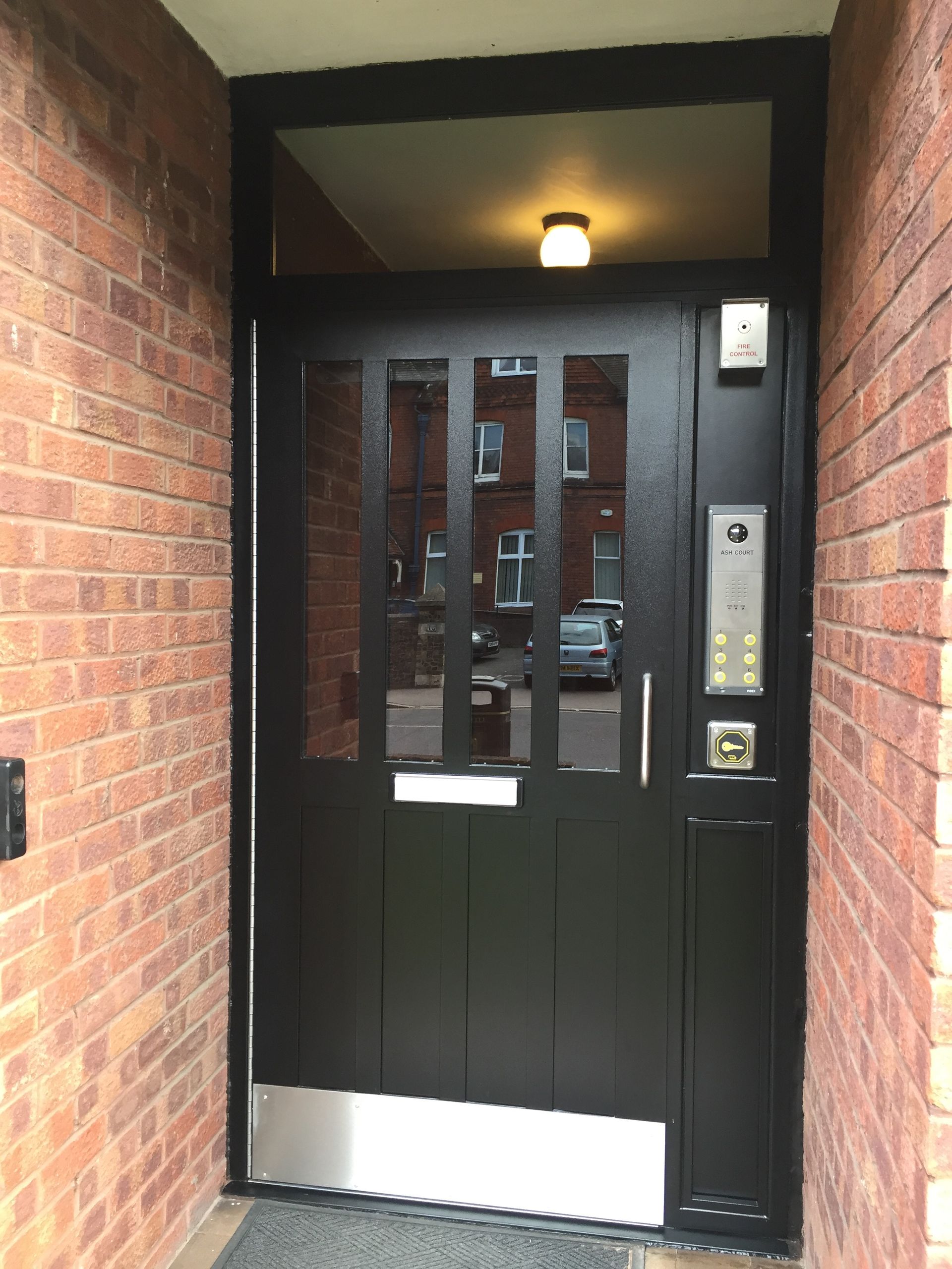 a black door in a brick building with a silver trim