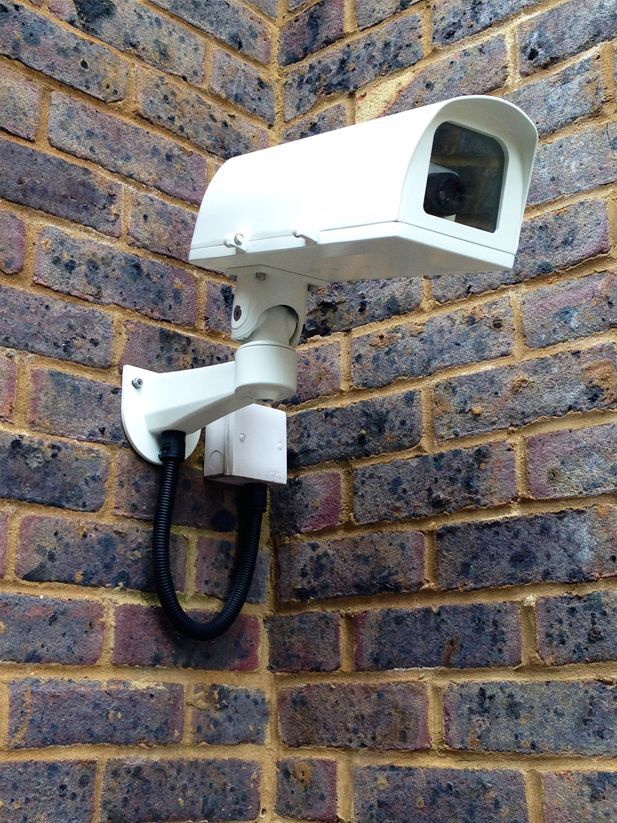 a security camera mounted on a brick wall
