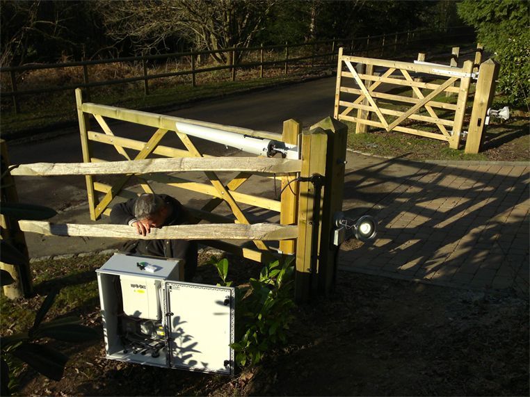 a man is working on a wooden gate with a box that says ' aol ' on it