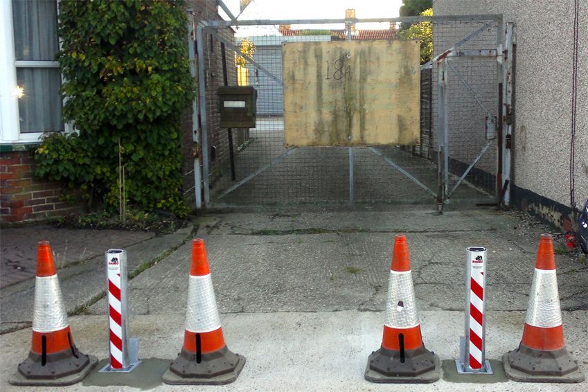 a row of traffic cones are lined up in front of a gate with the number 18 on it