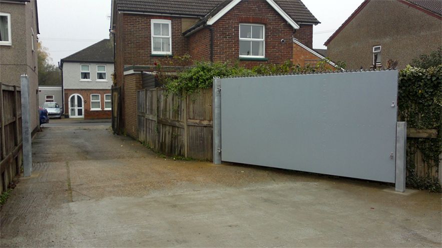 a brick house with a fence and a gate in front of it