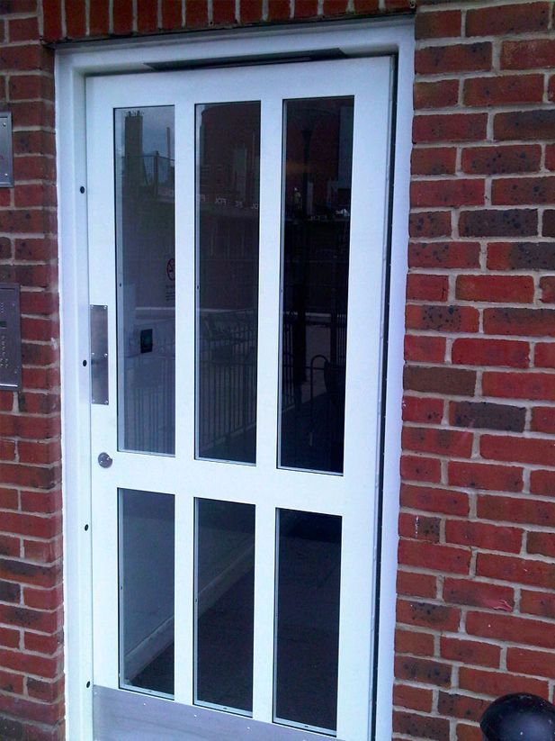 a white door with a brick wall behind it