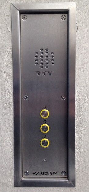 a stainless steel doorbell is mounted on a white wall .