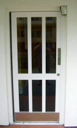 a man is taking a picture of himself in front of a white door .