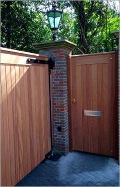 a wooden gate is surrounded by a brick wall