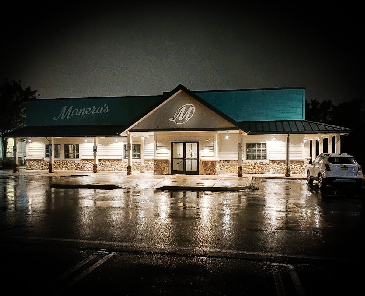 A restaurant with a blue roof is lit up at night