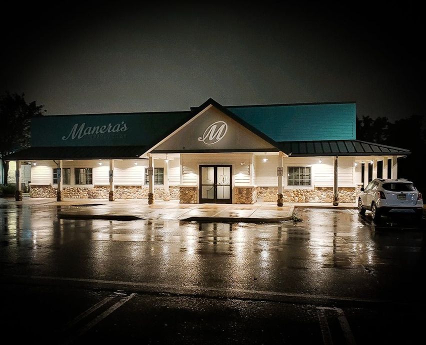 A restaurant with a blue roof is lit up at night