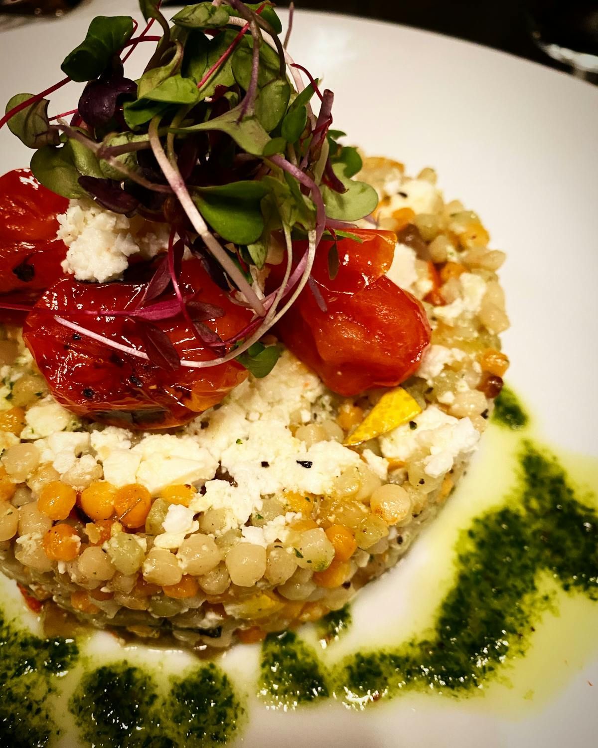 A close up of a plate of food with tomatoes and cheese