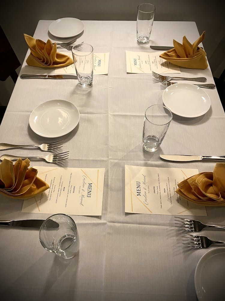 A table with plates , glasses , forks and knives on it