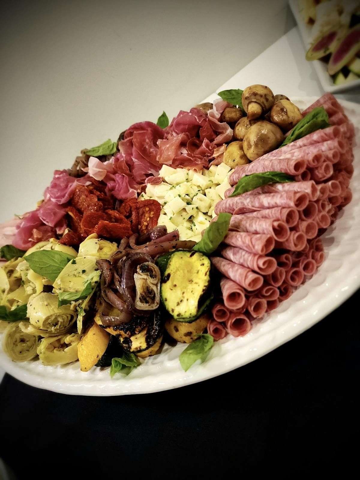 A white plate topped with meat and vegetables on a table.